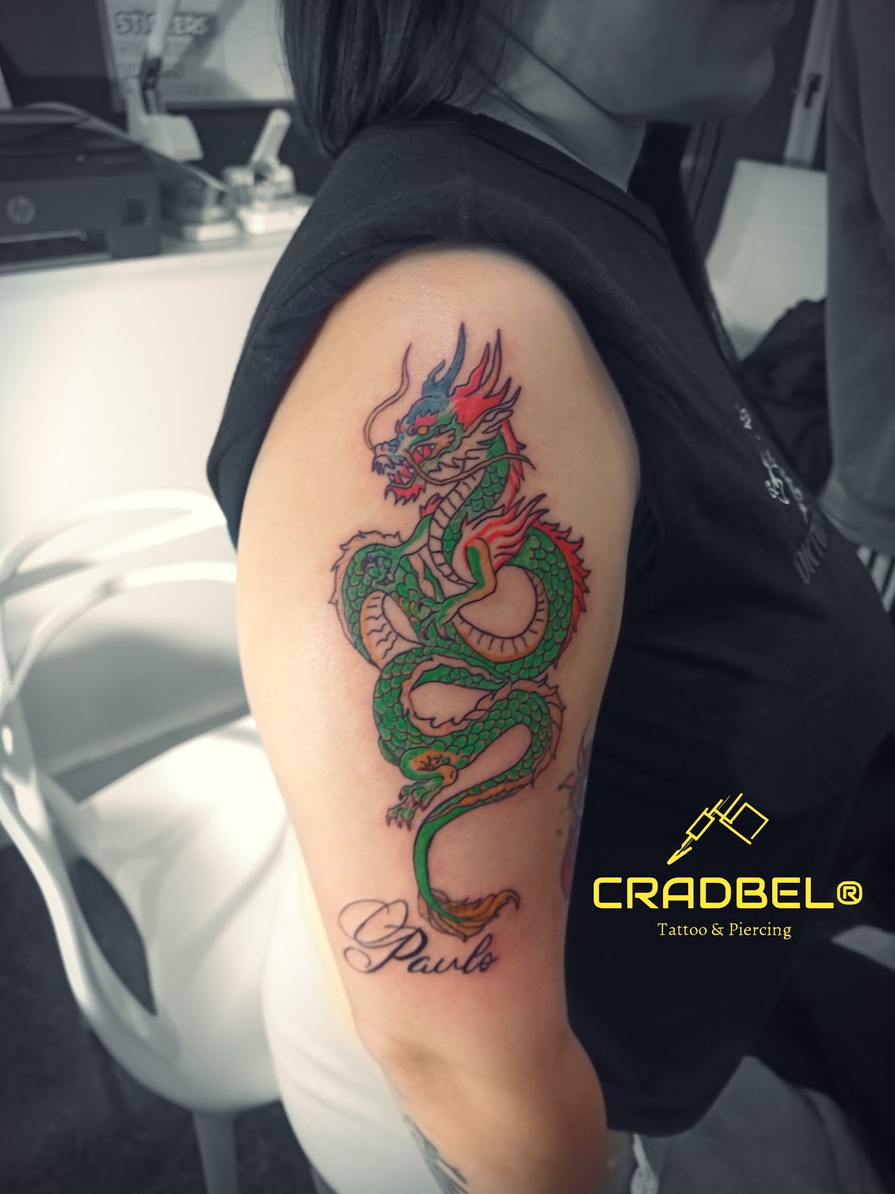 Tatuaje en antebrazo de máscara Hannya con flores en tonos rojos y dorados